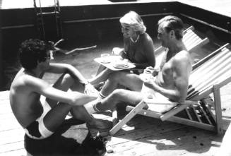 Photograph depicting passengers sitting by ORIANA's pool