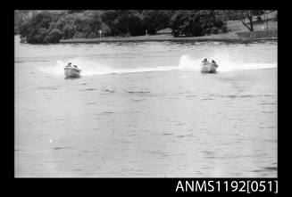 Black and white negative number 10 depicting two power boats with outboard engines under way