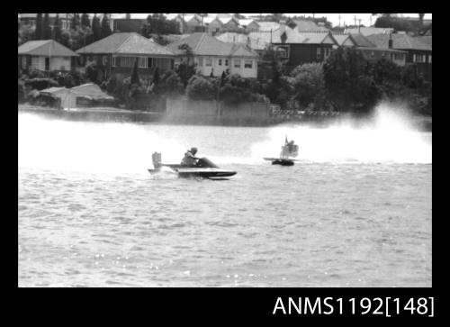 Black and white negative number 12 depicting power boat completing a turn at marker buoy