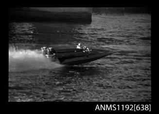 Black and white negative number 20A depicting view of QUICK-CAT with twin Chrysler outboard engines at speed, elevated starboard side view