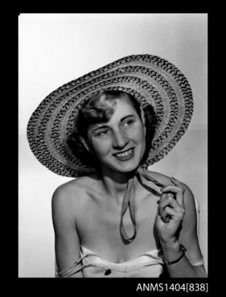 Photographic negative of a model posing with a hat