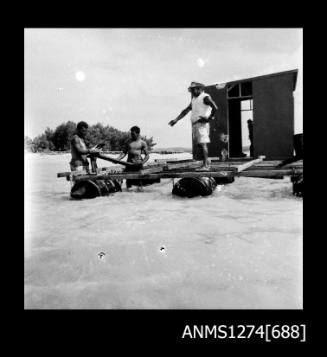 Three men constructing a lab on Packe Island