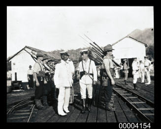 A contingent of the Australian Naval Expeditionary Force to New Guinea being inspected by a Japanese Admiral at Rabaul wharf in 1914