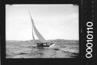Portside view of a half-decker sailing on Sydney Harbour