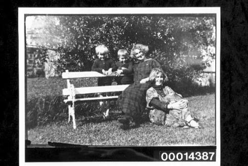Two young women with two children at a garden seat