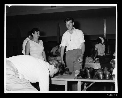 People looking at a bench with display of used footware